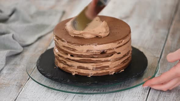 Step by step. Pastry chef making chocolate layer cake with prune filling. 