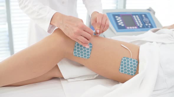 Myostimulation on the Legs and Hips of a Slim Fit Woman in Beauty Salon