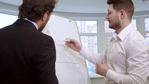 Businessman Draws on the Flip Chart