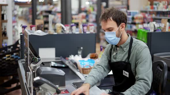 Sales Clerk in Mask Working at Grocery Store