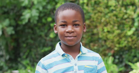 Animation of happy african american boy looking at camera in garden