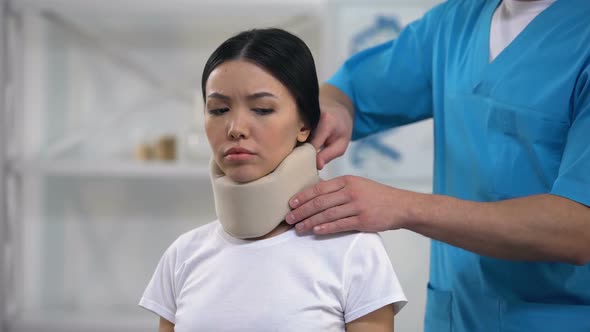 Male Orthopedist Fixing Sad Female Patient Foam Cervical Collar After Trauma