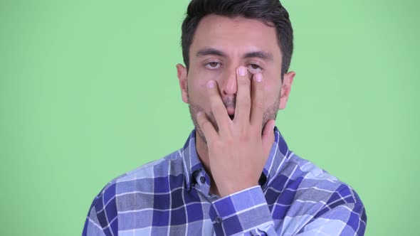 Closeup of Stressed Young Hispanic Man with Face Palm Gesture