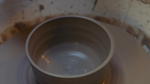 Potter making a earthen pot on a pottery wheel