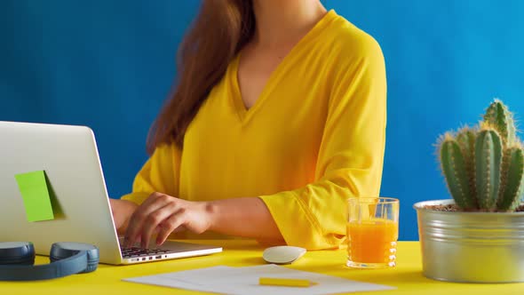Woman in a Yellow Blouse Works Remotely at Home During a Pandemic
