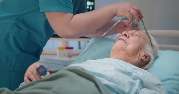 Nurse Putting Oxygen Mask Off Aged Patient and Turning Off Monitor with Vital Signs