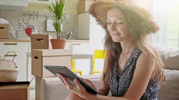 Woman Using Tablet with Boxes at the Back. Portrait of Young Beautiful Woman with Mobile Phone