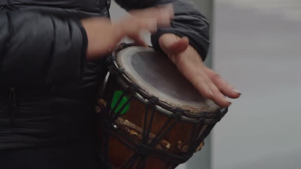 Closeup Street Musician Playing Rhythm on Drum in Town After Rain