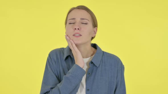 Young Woman Having Toothache Cavity on Yellow Background