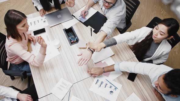 Diverse Young Colleagues Smiling Putting Their Hands on Top of Each Other After Productive Work on