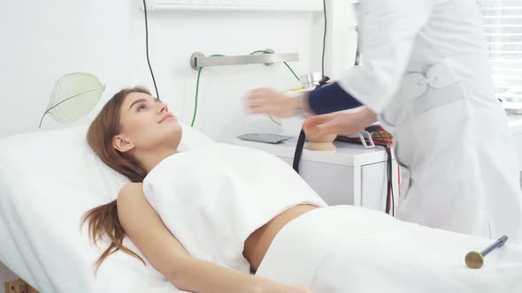 Beauty Salon. Young Attractive Girl in a Cosmetic Salon Lying on the Table Takes Electro Therapy