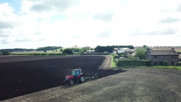 Aerial footage over tractor ploughing field