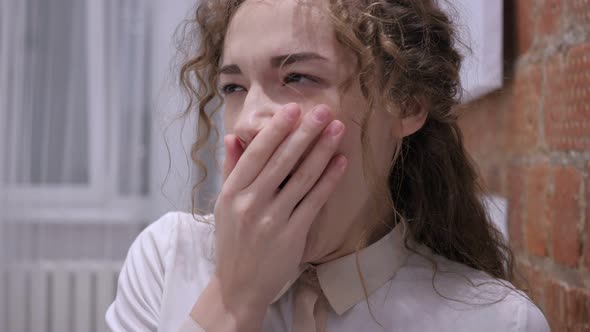 Yawning Tired Young Female Sitting in Office