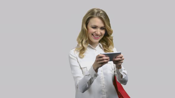 Young Attractive Woman in Formal Shirt Playing Game on Her Smartphone