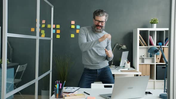 Joyful Mature Businessman Dancing Having Fun Relaxing Indoors in Office