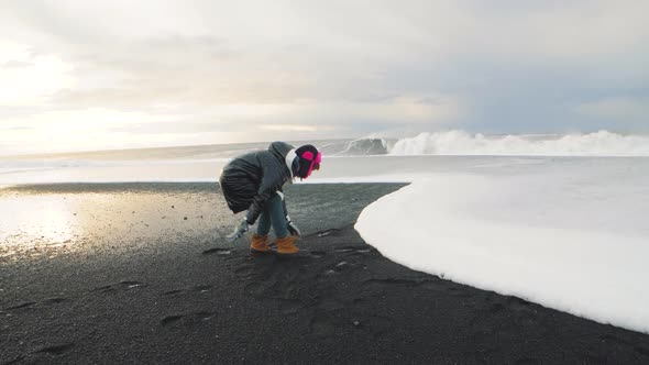 Woman Traveler Running on Volcanic Black Sand Beach in Iceland and Having a Good Time