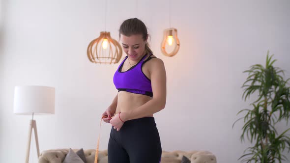 Happy Woman Measuring Her Waist with Tape Measure