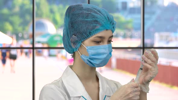 Young Nurse Filling Syringe with Medicine From the Vial