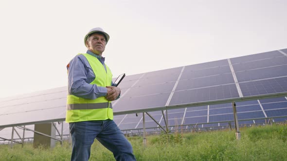 Mature Engineer Man Hand in Solar Panels Industrial Area