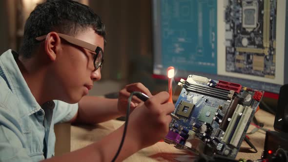 It Boy Is Soldering Electronic Circuit And Works With Computer In Home, Display Showing Cad Software