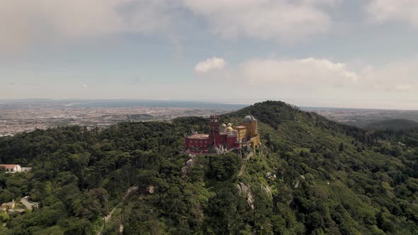 Spectacular panoramic shot of Sintra hills sky castle, mountaintop Pena palace with cloudscape.