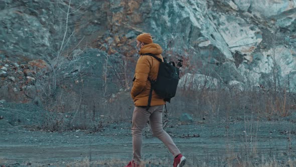 Man Photographer Walking in the Mountains the Background of Rocks