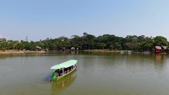 Peaceful 4k daytime aerial video capturing a man steering a boat on the soothing waters of Laguna de