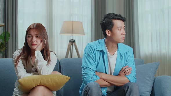 Sad Frustrated Young Asian Couple Being In Quarrel Sitting On Sofa In Living Room
