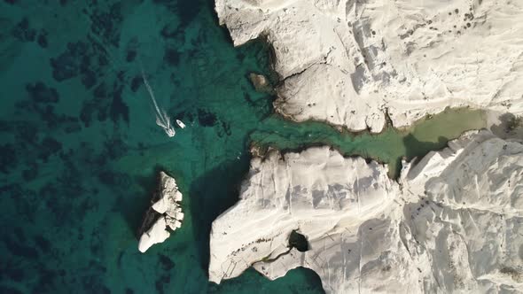 Rising shot of boat passing through crystal clear water on the Mediterranean coast.  Summertime Milo