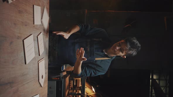 Vertical Video of Confident Young Craftsman Stands Near a Work Table in a Carpentry Workshop