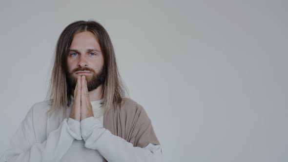 Jesus Prays with His Hands Together Looking at the Camera on a White Background