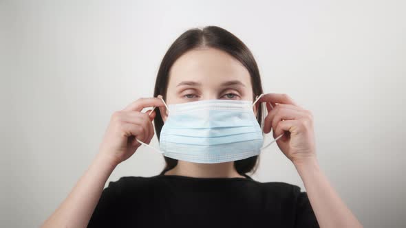 Pandemic Portrait of a Young European Smiling Woman Wearing Protective Mask on Home Isolation