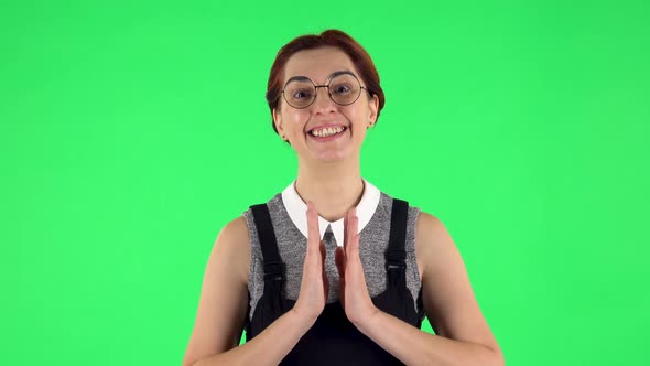 Portrait of Funny Girl in Round Glasses Is Looking with Tenderness with Folded Arms in Front