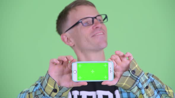 Face of Happy Nerd Man Thinking While Showing Phone