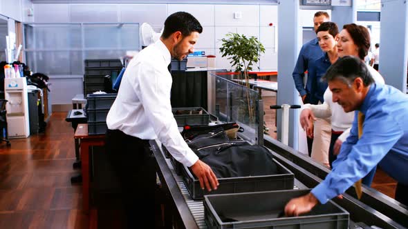 Male security staff assisting commuters with their baggage