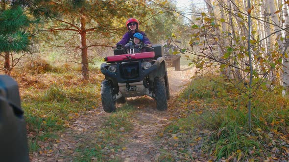 Big Family Rides Quad Bikes in the Autumn Forest