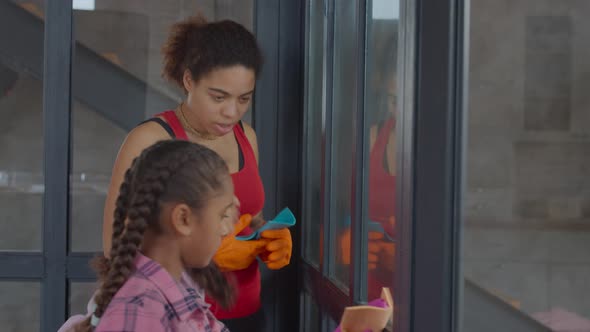 Family Washing Window Glass with Cleaning Supplies