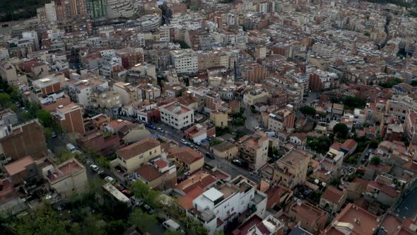 Top down aerial view above Barcelona valley neighbourhood tilt up to reveal Bunker De Carmel hillsid