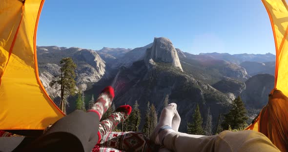 Two People Rest in a Tent Overlooking the Yosemite Valley.They Point Their Fingers at Half Dome Rock