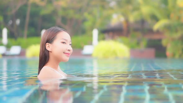 Young asian woman enjoy around outdoor swimming pool for leisure