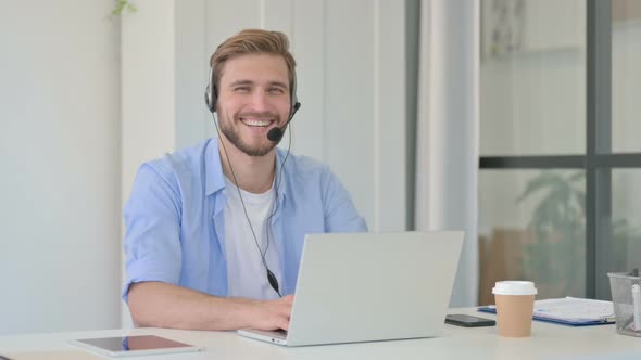 Creative Man with Headset and Laptop Smiling at Camera