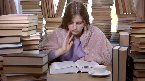 A Girl Reads a Book in the Library