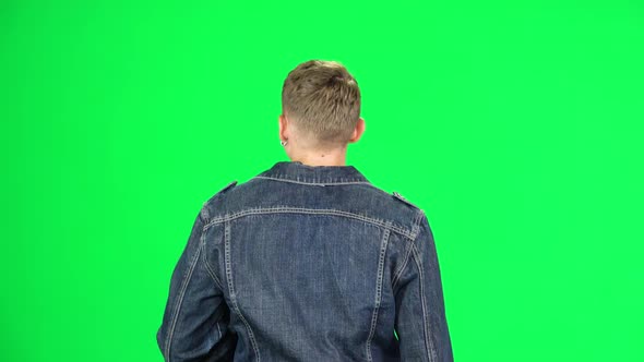 Back View of Guy Is Walking and Drinking Coffee From a Paper Cup