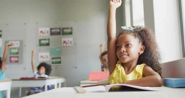 Video of happy african american girl raising hand during lesson