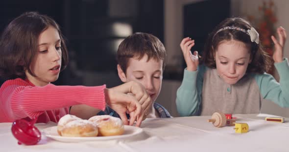 Kids playing with dreidels during Hanukka at home