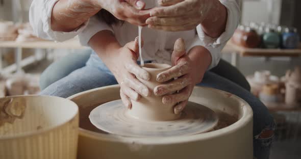 Loving Couple Working on Poterry Wheel in Pottery Workshop