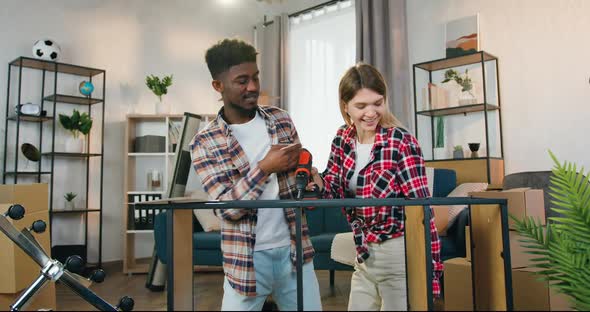 Couple Assembling Together the Rack Using Electric Cordless screwdriver