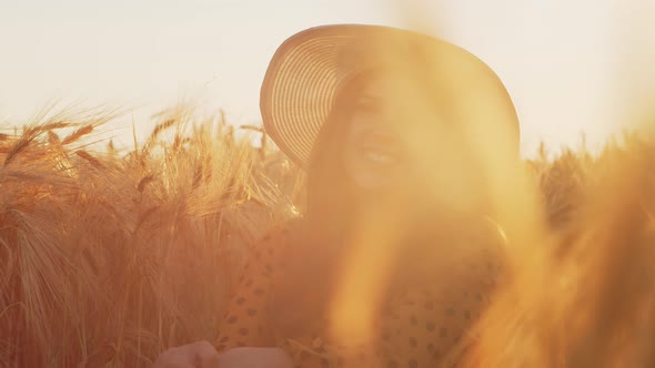 Pregnant woman in the rays of the sunset in the field