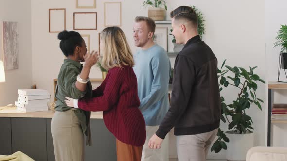 Young Woman Greeting Friends at Home