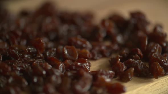 Pan across a bunch of delicious raisins on a wood cutting board